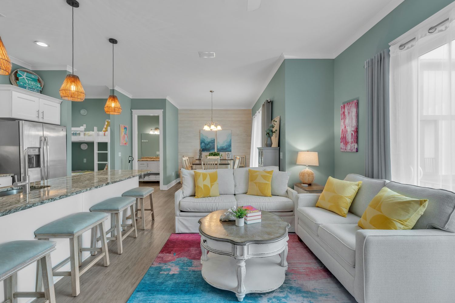 Open living, dining and kitchen under vaulted ceilings