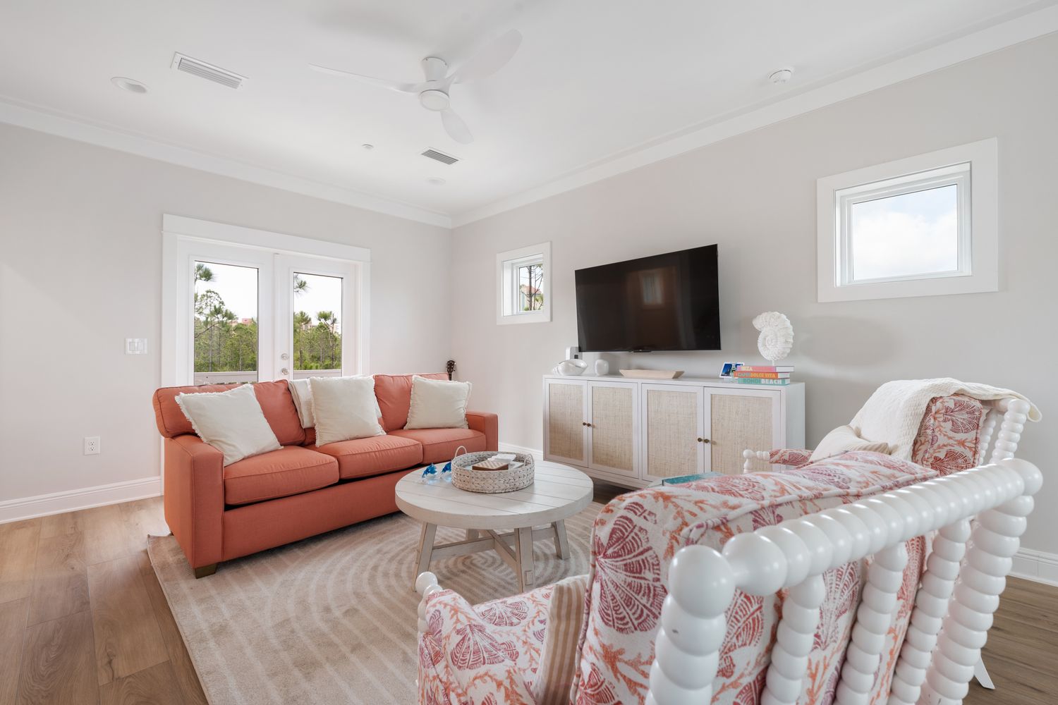 Open living room with coral sofas under vaulted ceilings
